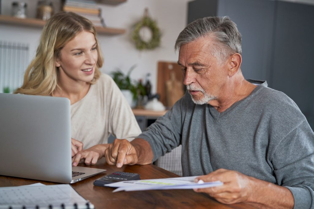 senior-man-with-adult-daughter-looking-for-solutio-2022-09-23-02-24-13-utc _ resized Senior man with adult daughter at a table with a computer - Medicaid Planning and Long-Term Care