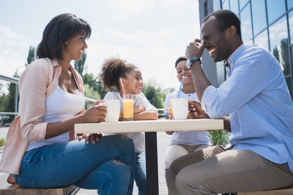 middle class African-American family in cafe sitting outdoors
