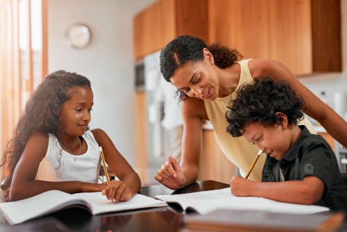 Mother helping her children with homework at home – Estate Planning for New York Moms